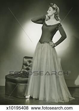 Stock Photo - woman in evening 
dress standing 
indoors, holding 
hand on cheek, 
(b&w). fotosearch 
- search stock 
photos, pictures, 
images, and photo 
clipart