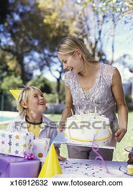 Stock Photo - mother and son 
(6-8) at birthday 
party, mother 
holding birthday 
cake. fotosearch 
- search stock 
photos, pictures, 
images, and photo 
clipart