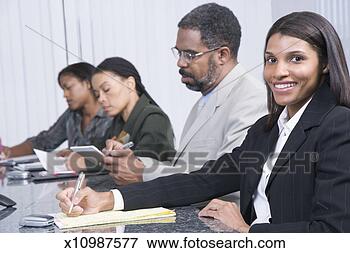 Picture - business people 
sitting at table 
during business 
meeting,  woman. 
fotosearch - search 
stock photos, 
pictures, images, 
and photo clipart