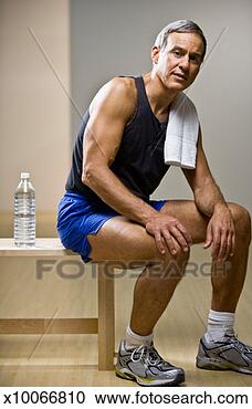 Stock Photography - mature man sitting 
on bench in gym 
with towel on 
shoulder, portrait. 
fotosearch - search 
stock photos, 
pictures, images, 
and photo clipart