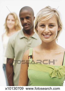 Stock Photograph - portrait of three 
young people standing 
in row,  smiling, 
 focus on. fotosearch 
- search stock 
photos, pictures, 
images, and photo 
clipart