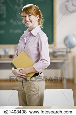 Stock Photo - young teacher 
standing in classroom, 
portrait. fotosearch 
- search stock 
photos, pictures, 
images, and photo 
clipart