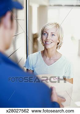 Stock Photo - young woman receiving 
parcel from delivery 
man, smiling. 
fotosearch - search 
stock photos, 
pictures, images, 
and photo clipart