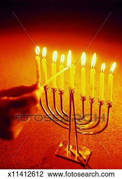 Stock Photo - man's hand lighting 
a menorah. fotosearch 
- search stock 
photos, pictures, 
images, and photo 
clipart