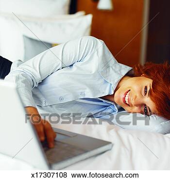 Stock Photo - close-up of businesswoman 
lying on bed with 
laptop beside 
her. fotosearch 
- search stock 
photos, pictures, 
images, and photo 
clipart