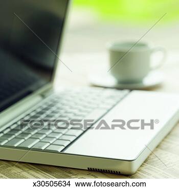 Stock Photo - close-up of laptop 
with cup and saucer 
beside it. fotosearch 
- search stock 
photos, pictures, 
images, and photo 
clipart