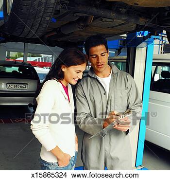 Stock Photo - front view of 
mechanic showing 
clip-board to 
customer. fotosearch 
- search stock 
photos, pictures, 
images, and photo 
clipart