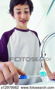 Stock Photo - close-up of boy 
rinsing toothbrush 
under tap (12-13). 
fotosearch - search 
stock photos, 
pictures, images, 
and photo clipart