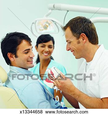 Stock Photo - close-up of dentist 
and dental nurse 
showing patient 
how to wash teeth. 
fotosearch - search 
stock photos, 
pictures, images, 
and photo clipart