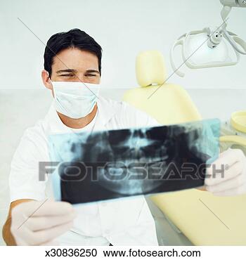 Stock Photography - close-up of dentist 
wearing surgical 
mask and gloves 
and examining. 
fotosearch - search 
stock photos, 
pictures, images, 
and photo clipart