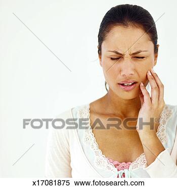 Stock Image - front view of 
young woman holding 
her cheek in pain. 
fotosearch - search 
stock photos, 
pictures, images, 
and photo clipart