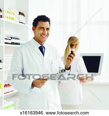 Stock Photo - close-up of male 
pharmacist holding 
container of medicine 
and rear. fotosearch 
- search stock 
photos, pictures, 
images, and photo 
clipart