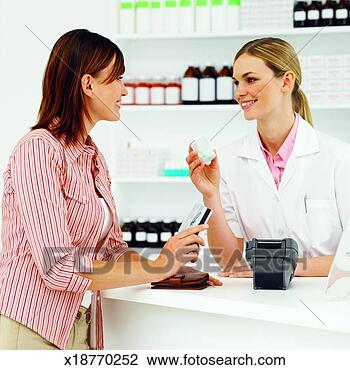 Stock Photo - side view of pharmacist 
showing patient 
container of tablets. 
fotosearch - search 
stock photos, 
pictures, images, 
and photo clipart