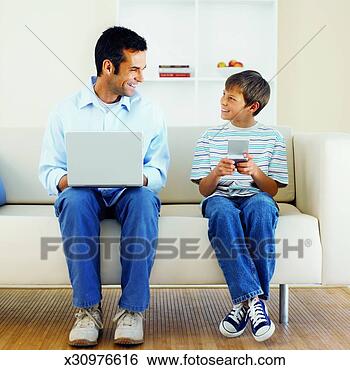 Stock Photo - close-up of father 
working on laptop 
and son (11-12) 
playing computer. 
fotosearch - search 
stock photos, 
pictures, images, 
and photo clipart