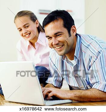 Stock Photo - father working 
on laptop and 
daughter (11-12) 
watching him. 
fotosearch - search 
stock photos, 
pictures, images, 
and photo clipart