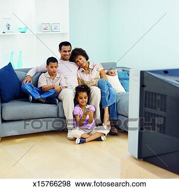 Stock Photo - front view of 
parents and two 
children watching 
television (9-11). 
fotosearch - search 
stock photos, 
pictures, images, 
and photo clipart