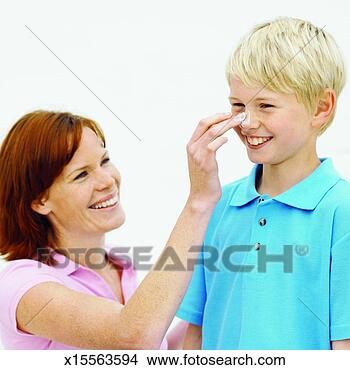 Stock Photo - mother putting 
sun cream on her 
son (6-7). fotosearch 
- search stock 
photos, pictures, 
images, and photo 
clipart