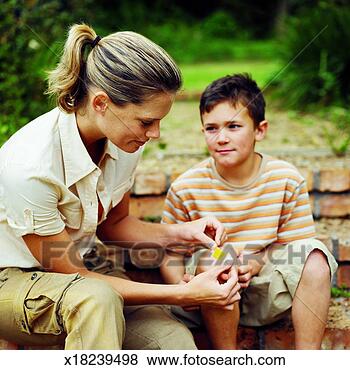 Stock Photo - close-up of mother 
putting plaster 
on son's knee 
(10-11). fotosearch 
- search stock 
photos, pictures, 
images, and photo 
clipart