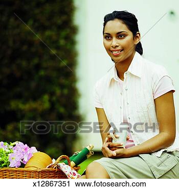 Stock Photography - close-up of woman 
holding mug of 
coffee with gardening 
kit beside her. 
fotosearch - search 
stock photos, 
pictures, images, 
and photo clipart
