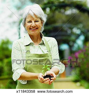 Stock Photo - front view of 
woman holding 
seedling. fotosearch 
- search stock 
photos, pictures, 
images, and photo 
clipart