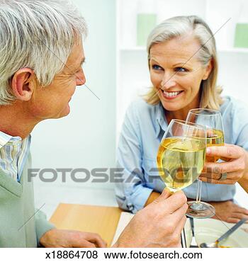 Stock Photo - mature couple 
sitting at table 
and toasting with 
glasses of wine. 
fotosearch - search 
stock photos, 
pictures, images, 
and photo clipart
