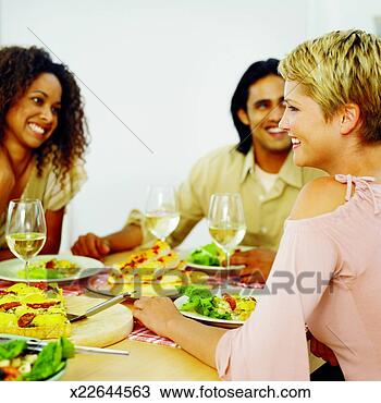 Stock Photo - three young people 
sitting at table 
eating dinner. 
fotosearch - search 
stock photos, 
pictures, images, 
and photo clipart