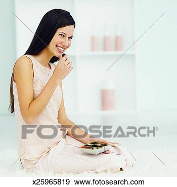 Stock Photograph - woman enjoying 
a box of chocolates. 
fotosearch - search 
stock photos, 
pictures, images, 
and photo clipart