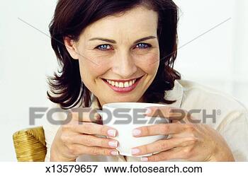 Picture - front view of 
young woman holding 
cup of coffee. 
fotosearch - search 
stock photos, 
pictures, images, 
and photo clipart
