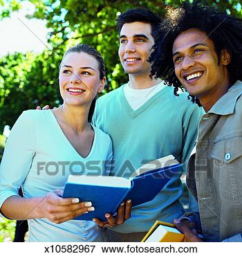Picture - close-up of three 
young people looking 
at book. fotosearch 
- search stock 
photos, pictures, 
images, and photo 
clipart