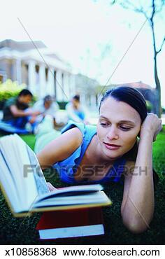 Stock Photo - close-up of young 
woman lying on 
grass reading 
book with three 
other. fotosearch 
- search stock 
photos, pictures, 
images, and photo 
clipart