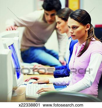 Stock Photography - side view of three 
young people sitting 
in computer lab. 
fotosearch - search 
stock photos, 
pictures, images, 
and photo clipart