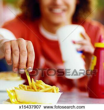 Picture - close-up of young 
man eating in 
fast food restaurant. 
fotosearch - search 
stock photos, 
pictures, images, 
and photo clipart
