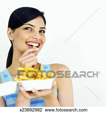 Stock Photo - close-up of young 
woman eating carton 
of french fries. 
fotosearch - search 
stock photos, 
pictures, images, 
and photo clipart