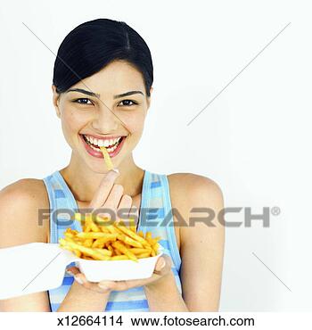 Stock Photo - front view of 
young woman eating 
carton of french 
fries. fotosearch 
- search stock 
photos, pictures, 
images, and photo 
clipart