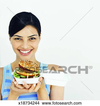 Stock Photo - front view of 
young woman holding 
burger. fotosearch 
- search stock 
photos, pictures, 
images, and photo 
clipart