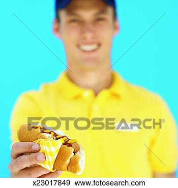 Stock Photograph - front view of 
young waiter holding 
hotdog. fotosearch 
- search stock 
photos, pictures, 
images, and photo 
clipart