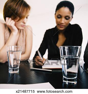 Stock Image - two glasses of 
water in front 
of two young businesswomen 
discussing. fotosearch 
- search stock 
photos, pictures, 
images, and photo 
clipart