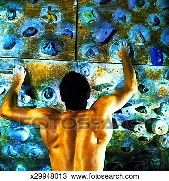 Stock Photo - rear view of a 
man practicing 
rock climbing 
on a man made 
rock. fotosearch 
- search stock 
photos, pictures, 
images, and photo 
clipart