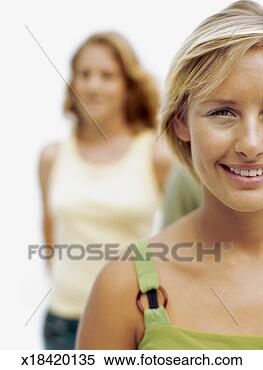 Stock Image - close-up of a 
young woman smiling 
with a young woman 
standing behind. 
fotosearch - search 
stock photos, 
pictures, images, 
and photo clipart