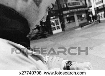 Stock Photo - young man checking 
his watch. fotosearch 
- search stock 
photos, pictures, 
images, and photo 
clipart