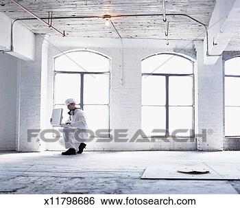 Stock Photo - man wearing a 
hazardous materials 
suit in an abandoned 
factory using. 
fotosearch - search 
stock photos, 
pictures, images, 
and photo clipart