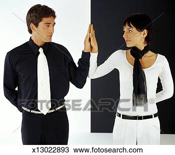 Stock Photo - young man and 
young woman, dressed 
in contrasting 
colors, touch 
hands. fotosearch 
- search stock 
photos, pictures, 
images, and photo 
clipart