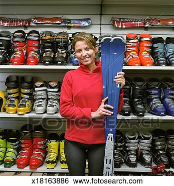 Stock Photo - woman beside ski 
boot display in 
sports shop, holding 
skis, portrait. 
fotosearch - search 
stock photos, 
pictures, images, 
and photo clipart