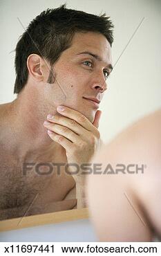 Stock Photography - man looking at 
himself in bathroom 
mirror. fotosearch 
- search stock 
photos, pictures, 
images, and photo 
clipart