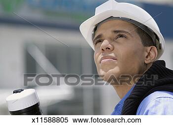 Stock Image - man in hard hat 
and woman looking 
up outdoors, close-up. 
fotosearch - search 
stock photos, 
pictures, images, 
and photo clipart