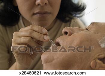 Stock Photography - a woman checking 
temperature of 
an elderly man 
with a thermometer. 
fotosearch - search 
stock photos, 
pictures, images, 
and photo clipart