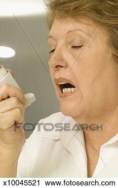 Stock Photography - close-up of an 
elderly woman 
using an inhaler. 
fotosearch - search 
stock photos, 
pictures, images, 
and photo clipart