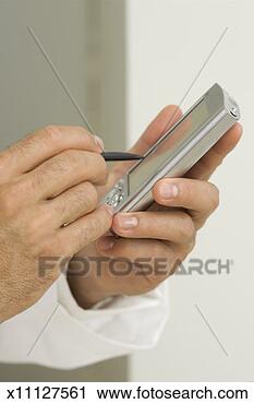 Stock Photography - man's hands entering 
data into a personal 
digital device, 
close-up. fotosearch 
- search stock 
photos, pictures, 
images, and photo 
clipart