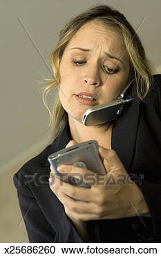 Stock Photography - young woman making 
notes and talking 
on a mobile phone. 
fotosearch - search 
stock photos, 
pictures, images, 
and photo clipart