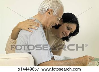Picture - senior man reading 
the newspaper 
with a young woman. 
fotosearch - search 
stock photos, 
pictures, images, 
and photo clipart